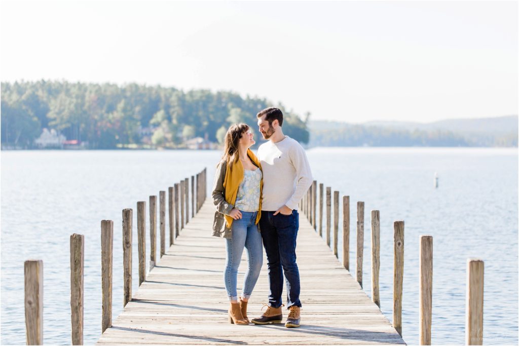 couple looking at each other on dock fall engagement photos