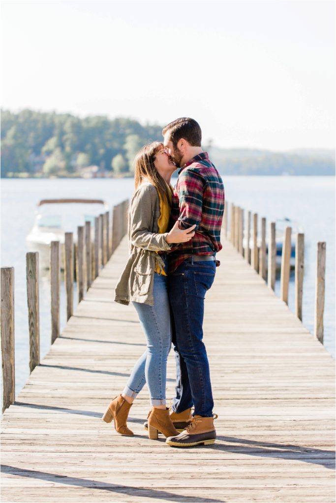 couple kissing on dock fall engagement photos