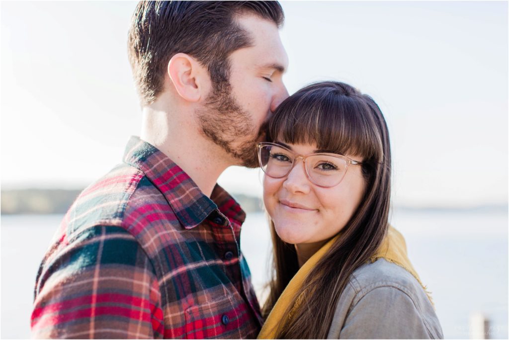 man nuzzling woman on docks fall engagement photos