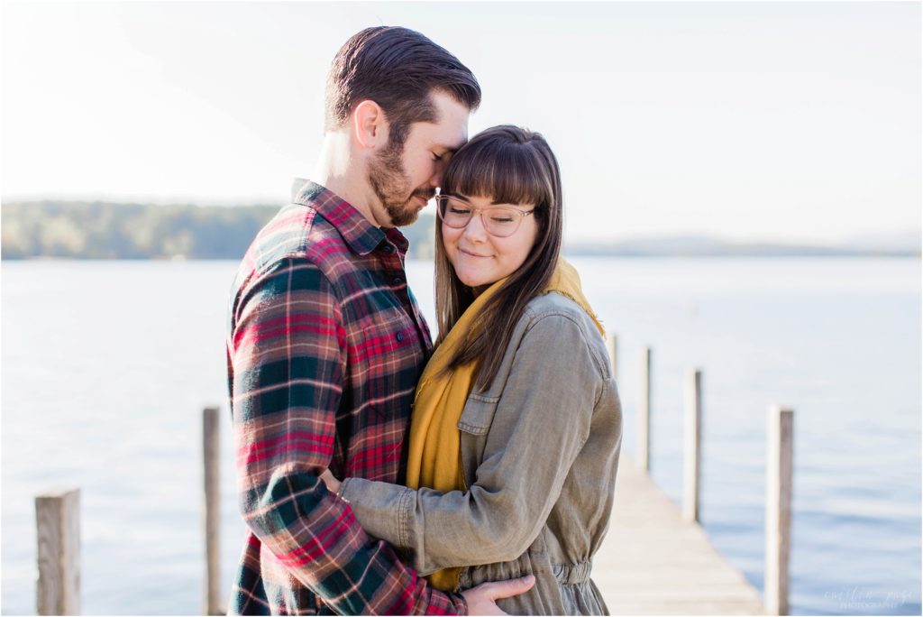 man nuzzling woman on docks fall engagement photos