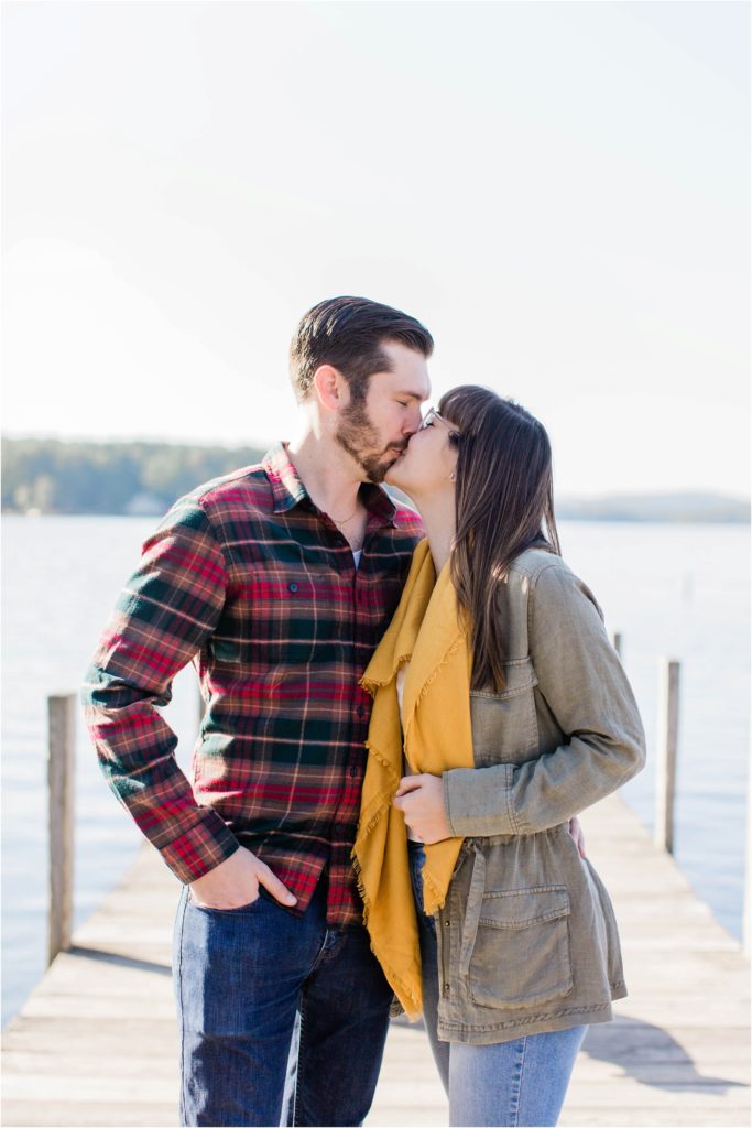 couple kissing on dock engagement photos