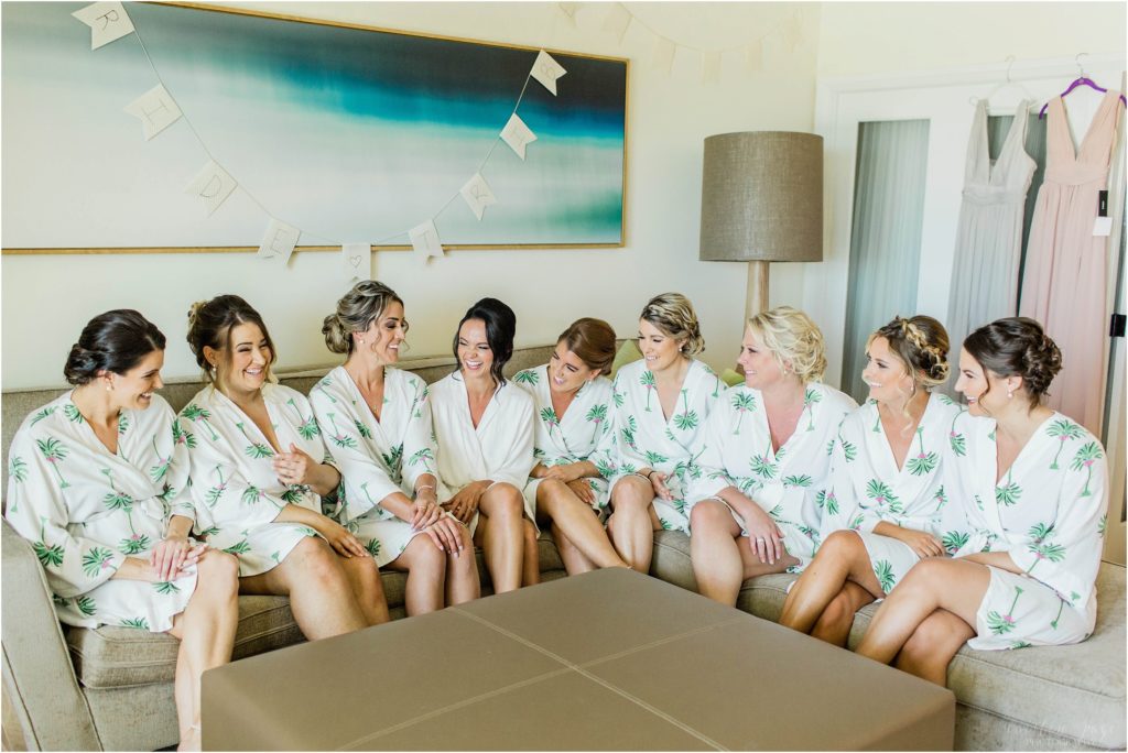 bridesmaids sitting together in matching palm tree robes
