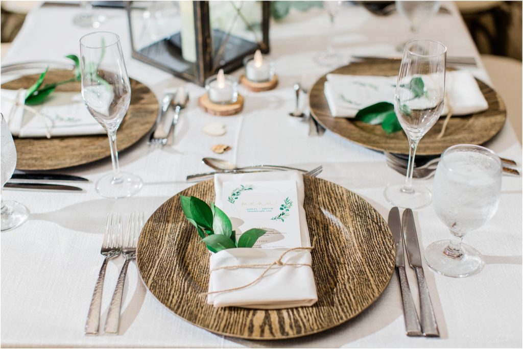 reception setting with wooden chargers and greens