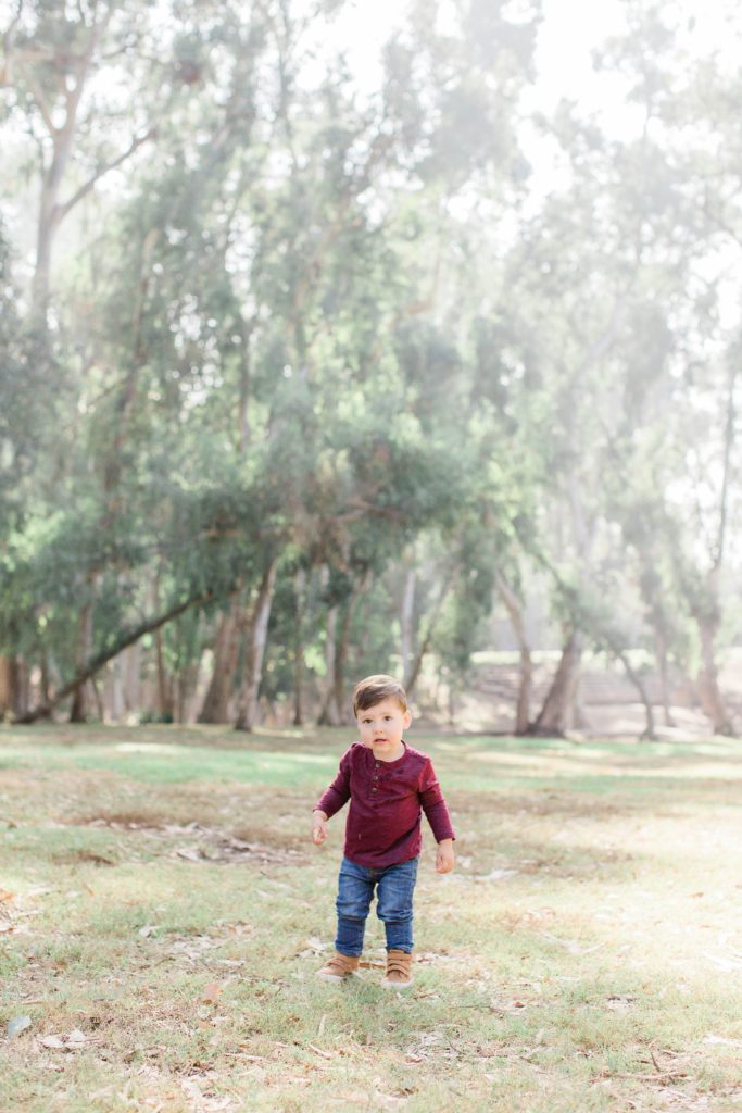 Little boy standing in middle of trees