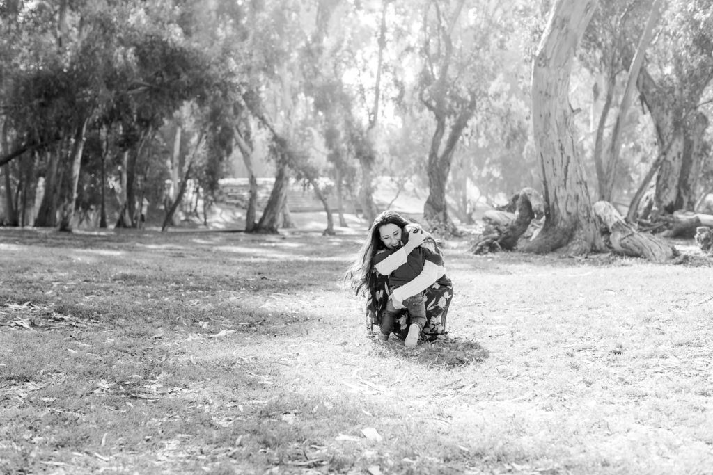 Black and white photo of mother hugging little boy