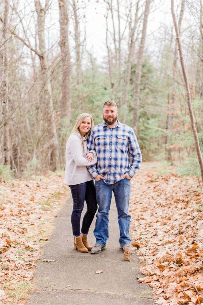 Couple standing in trail covered in leaves