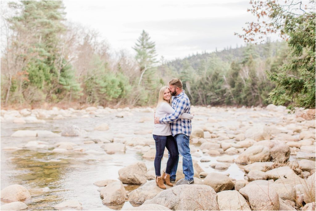 Man and woman standing together on rocks in middle of river
