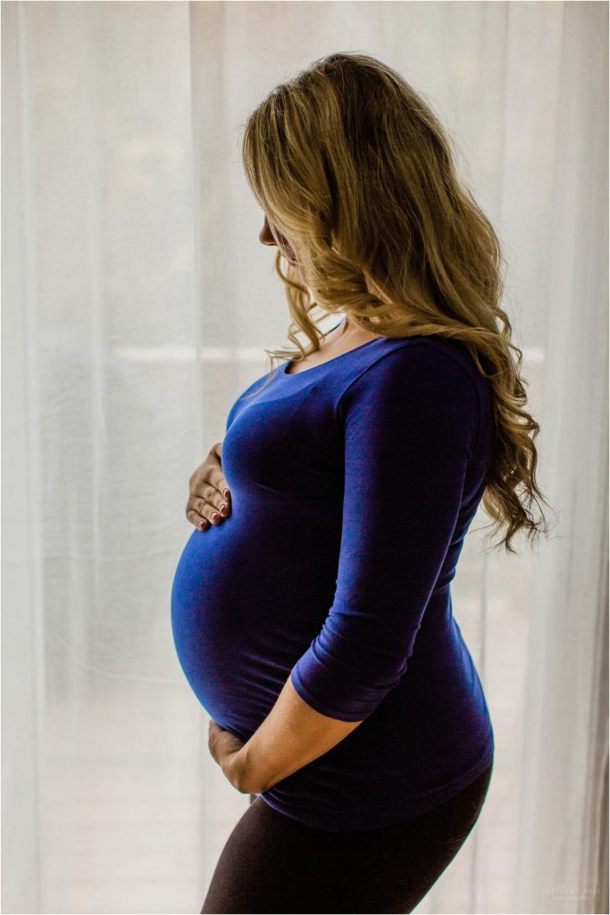 pregnant woman standing in front of window