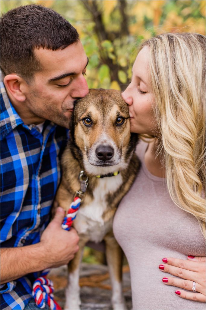 man and woman kissing dogs face between them