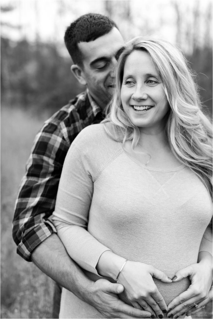 black and white photo of man and pregnant woman laughing