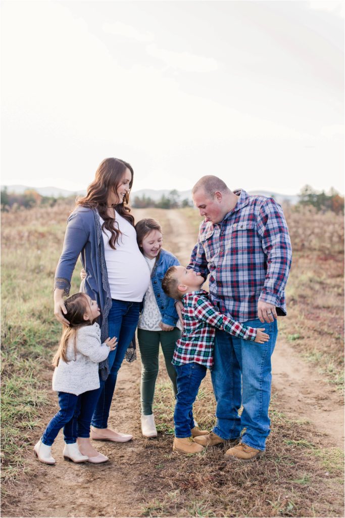 Family snuggling together in field