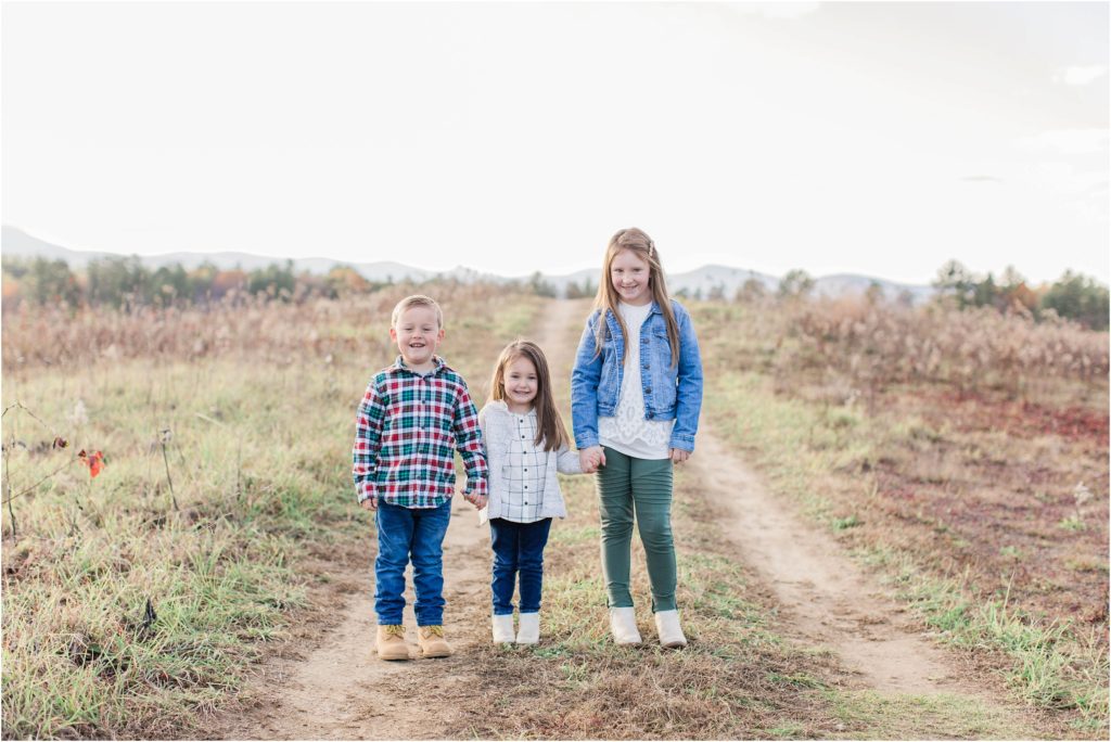 Siblings standing together in field