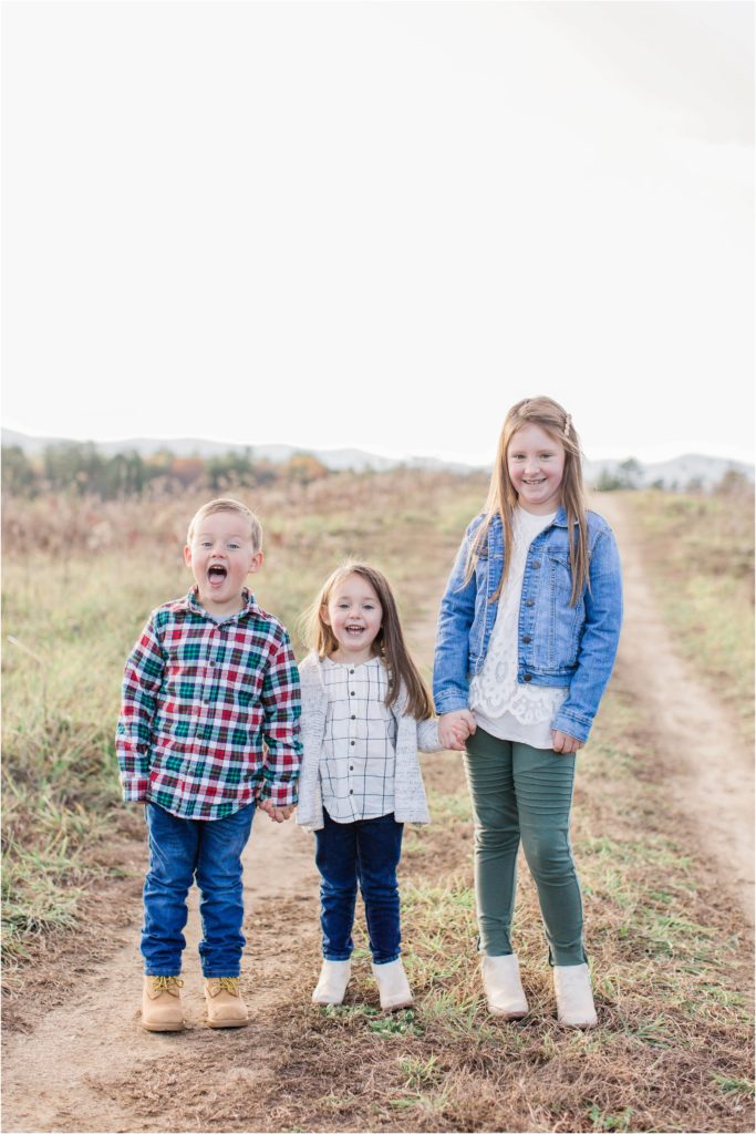 Siblings standing together in field