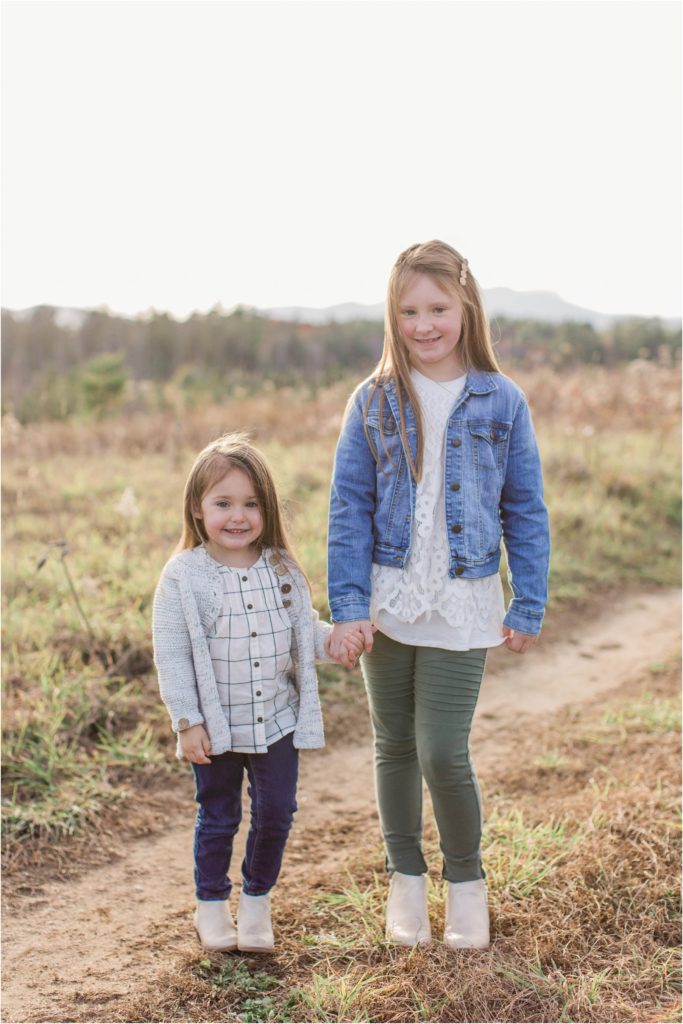 Sisters standing together in field