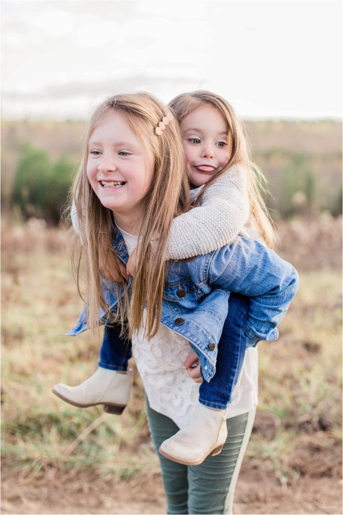 Older sister holding little sister on her back