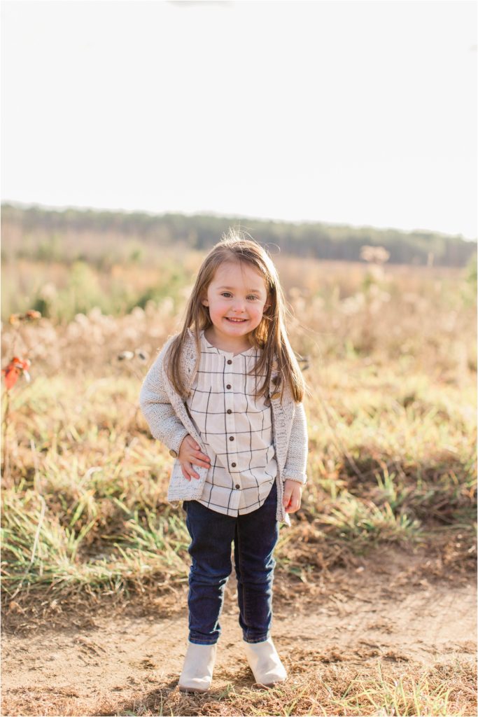 Little sister standing in field with hand on her hip