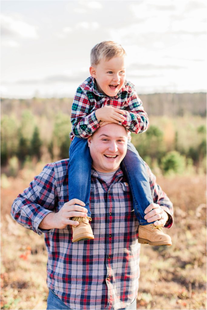 Dad holding little boy on his shoulders