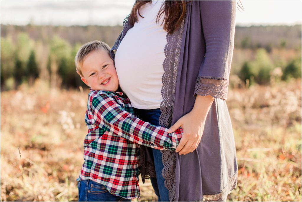 Little boy hugging moms pregnant belly