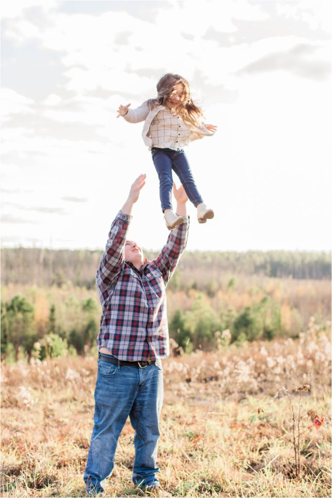 Dad throwing little girl in the air