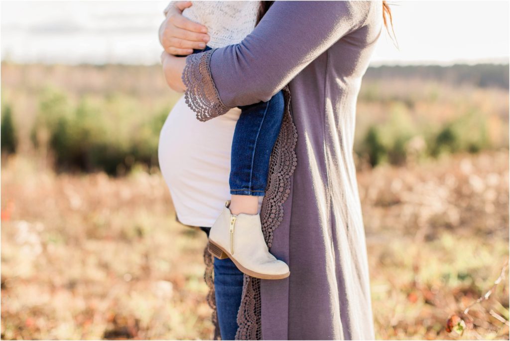 Little girl sitting on pregnant belly