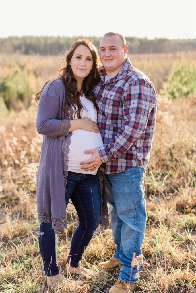 Man and pregnant wife smiling at camera