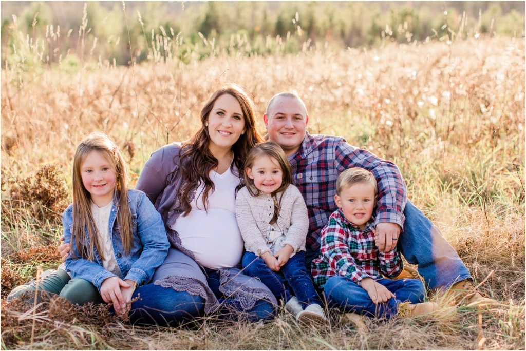 Family sitting together on the ground in a field