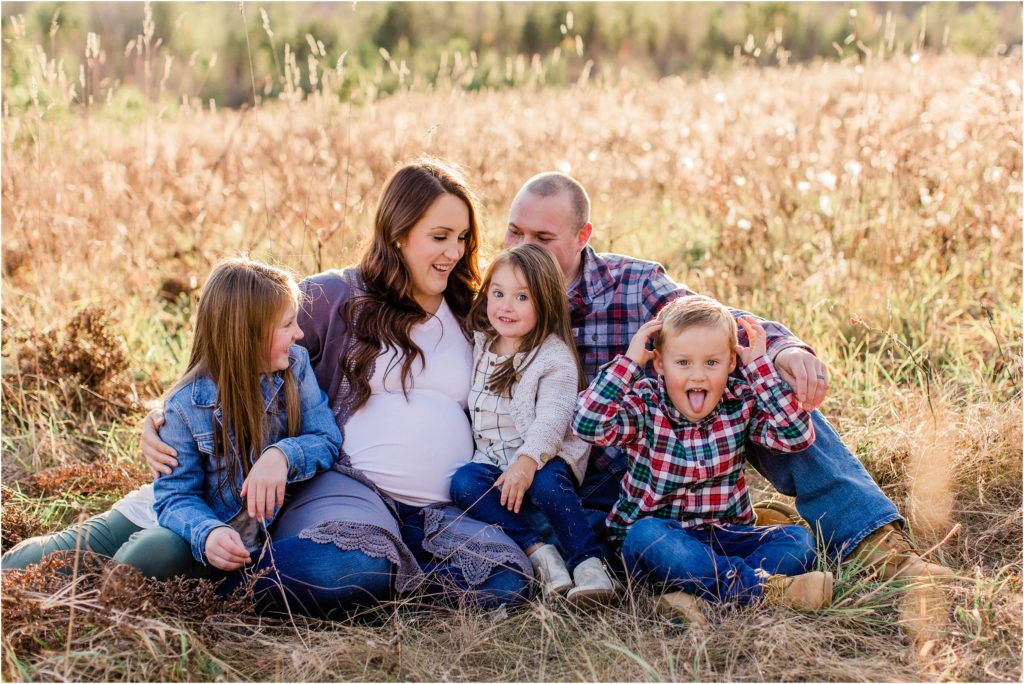 Family sitting together on the ground in a field