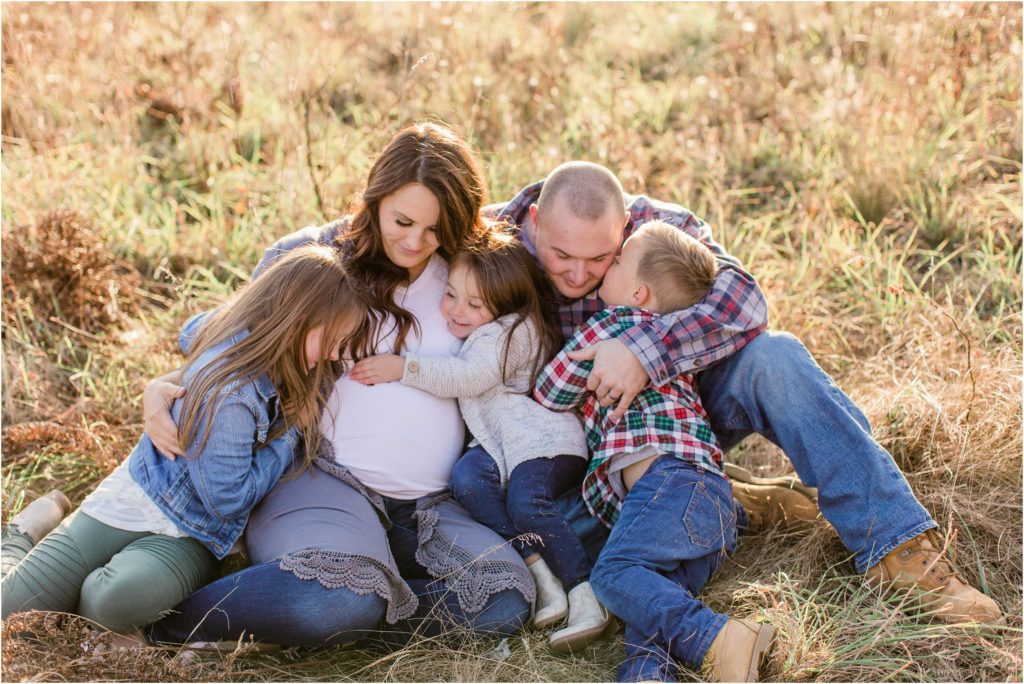 Family sitting together on the ground in a field