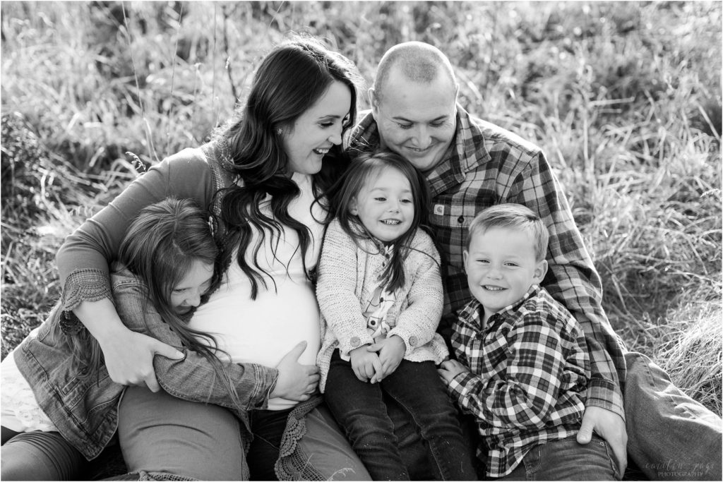 Family sitting together on the ground in a field