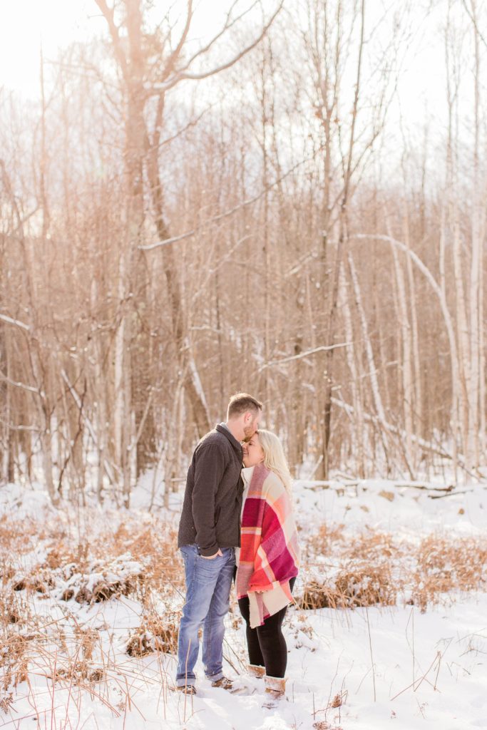 Snowy portrait of couple in the woods