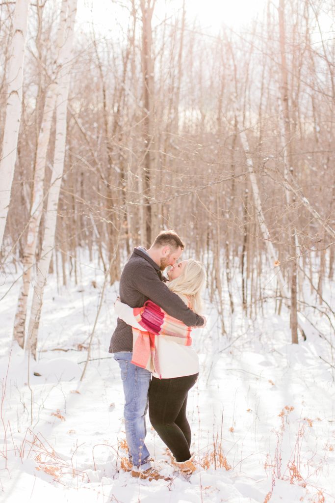 Couple hugging in the snowy woods