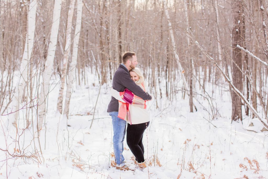 Couple hugging in the snowy woods
