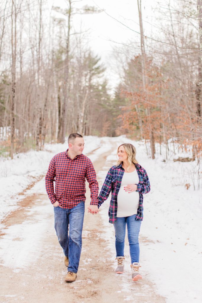Man and pregnant woman walking down dirt road together