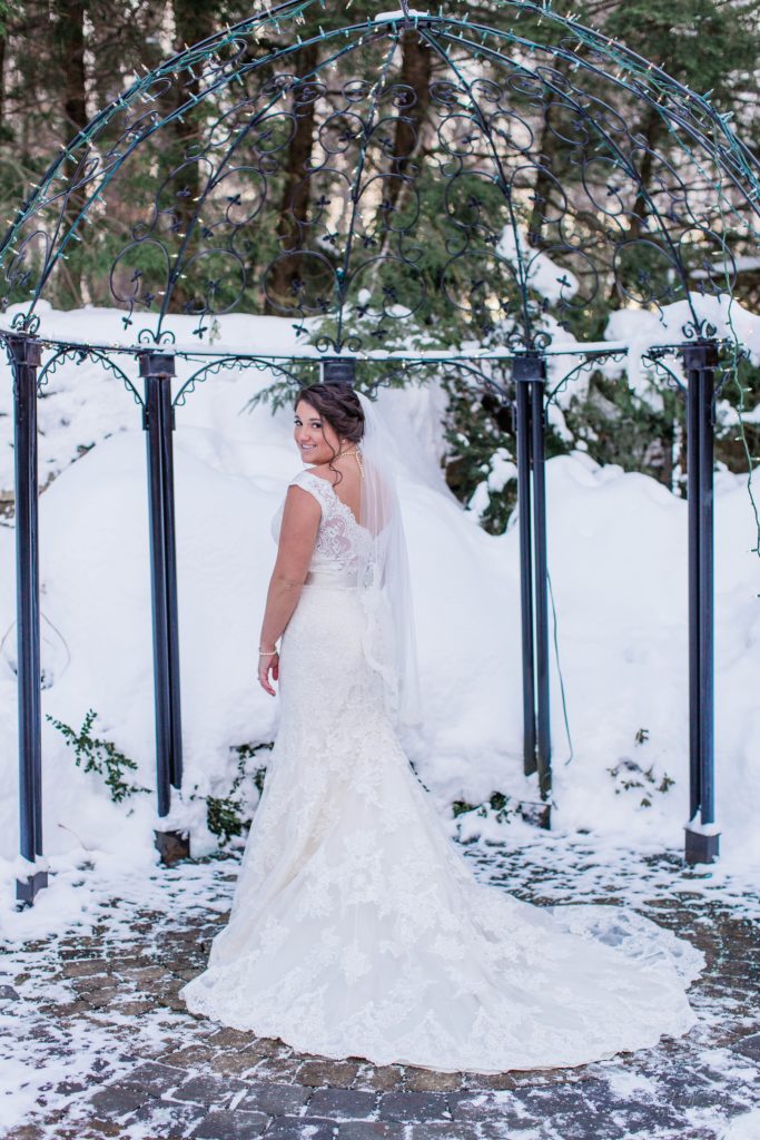 Bride standing outside in snow holding bouquet