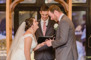 Groom putting wedding ring on bride