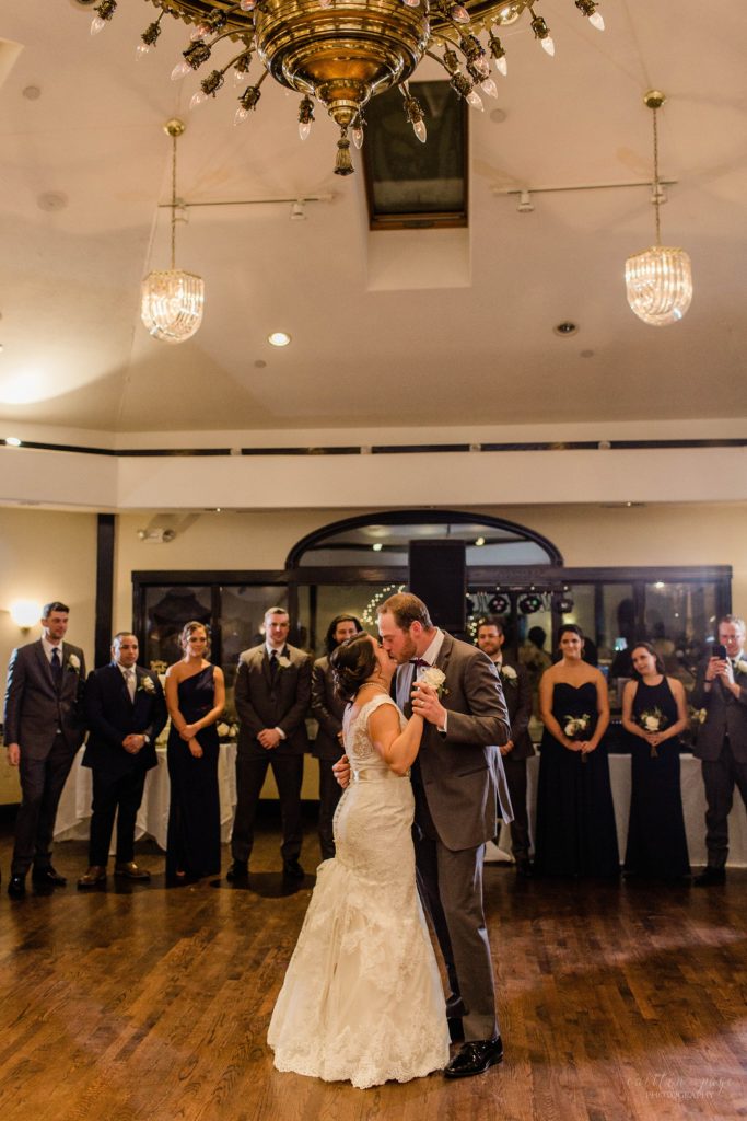 Bride and groom dancing together under chandelier at Wedgewood Granite Rose