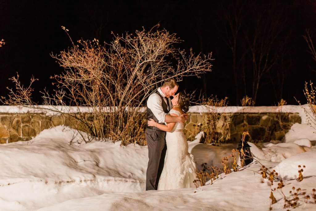 Bride and groom standing outside in the snow together