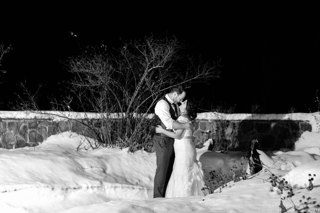 Bride and groom standing outside in the snow together