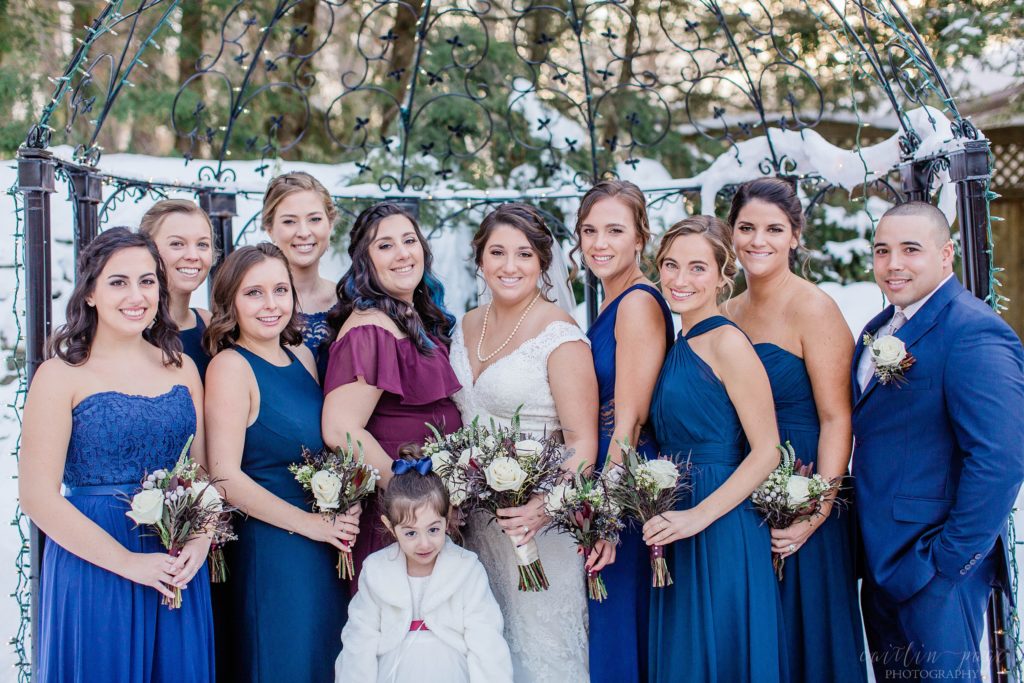 Bridesmaids and bride standing together outside in snow