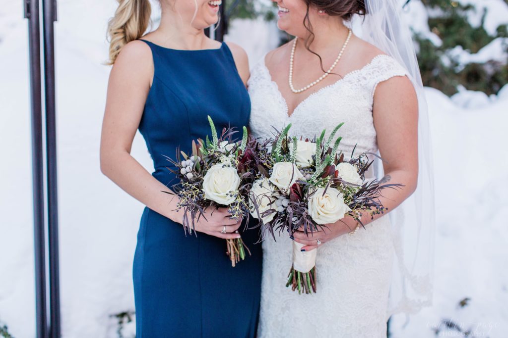 Bride and bridesmaid standing with bouquets