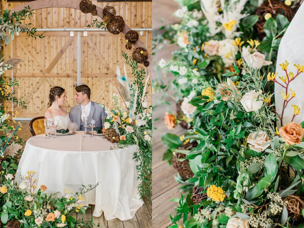 Couple sitting at head table with a hoop with floral display