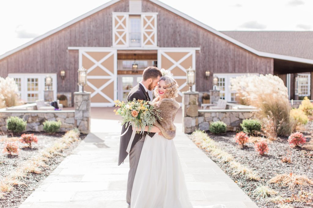Bride and groom kissing in front of barn at Mount Ida Farm in Charlottesville Virginia