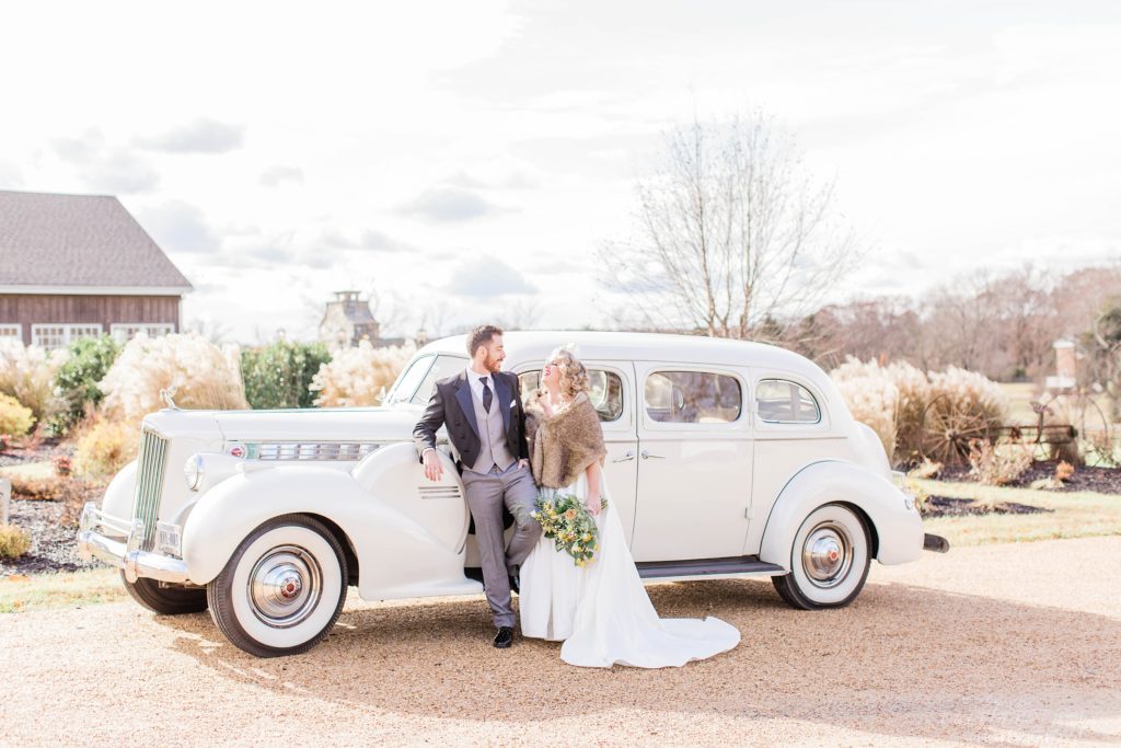 Bride and groom standing in front of vintage car at Mount Ida Farm in Charlottesville Virginia