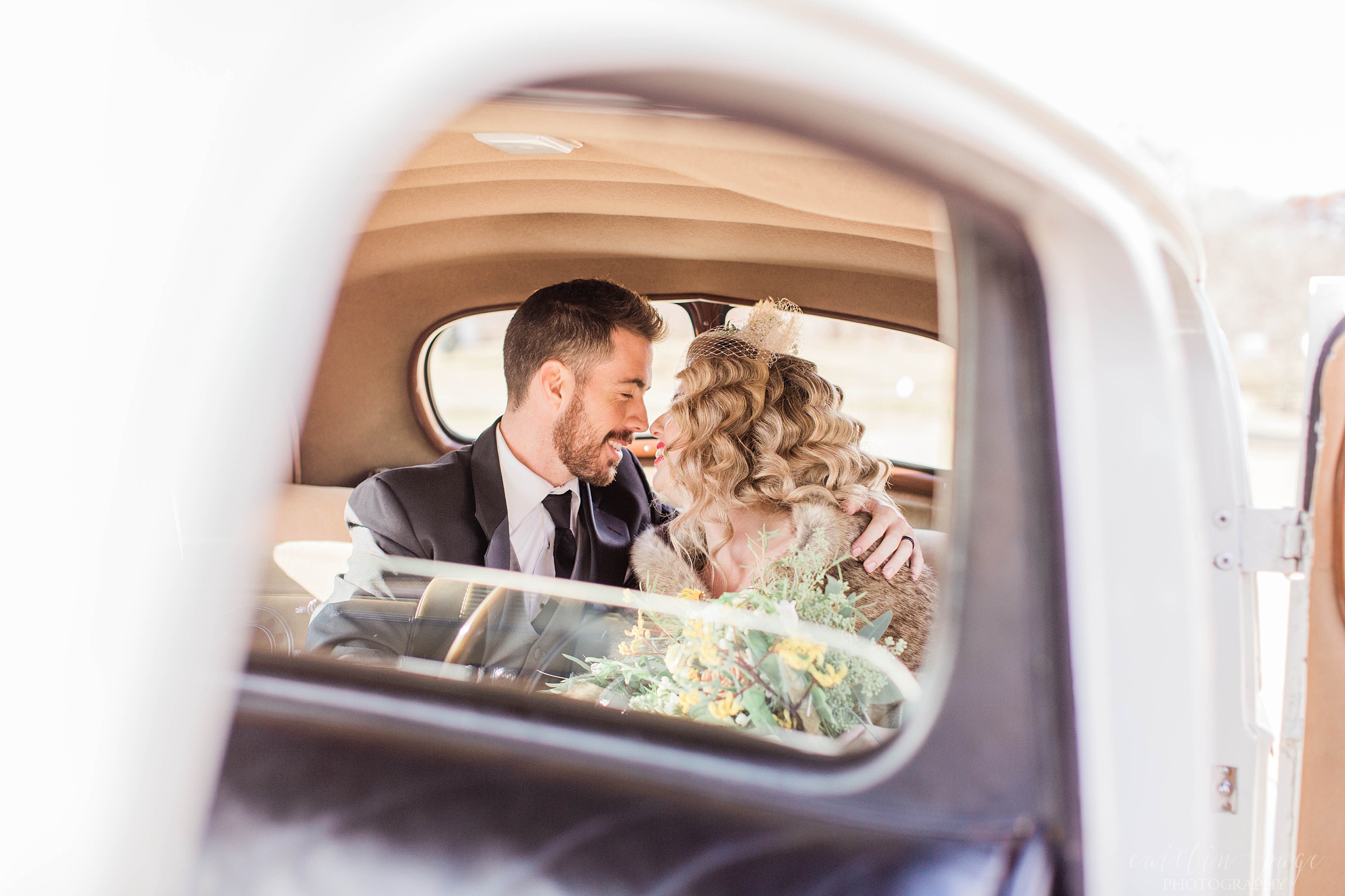 Bride and groom kissing in backseat of vintage car at Mount Ida Farm in Charlottesville Virginia