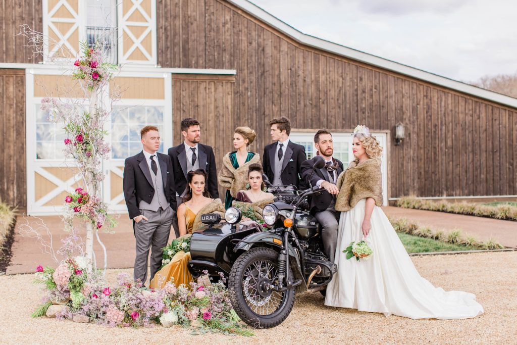Vintage styled bridal party grouped around vintage motorcycle at Mount Ida Farm in Charlottesville Virginia