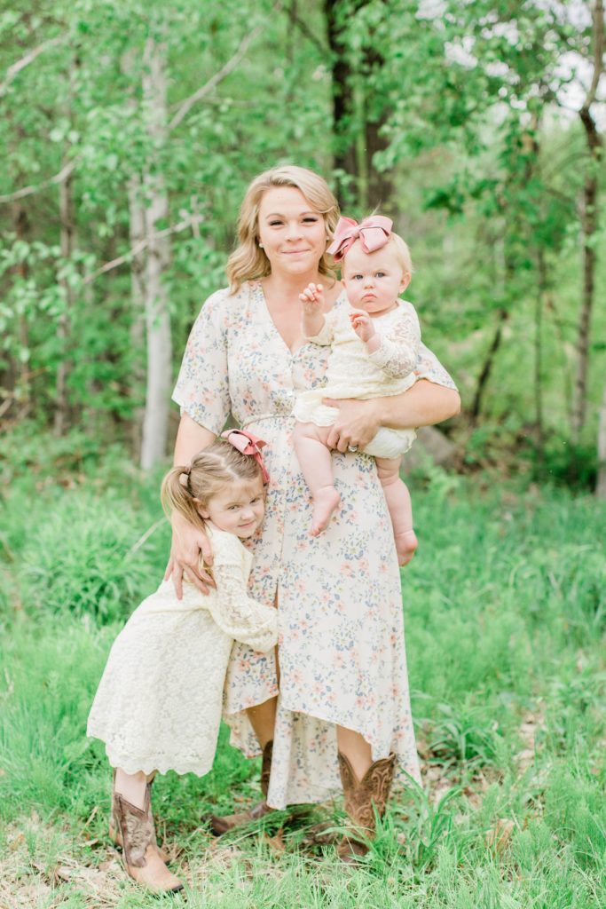 Mom holding her two daughters in dresses and cowboy boots