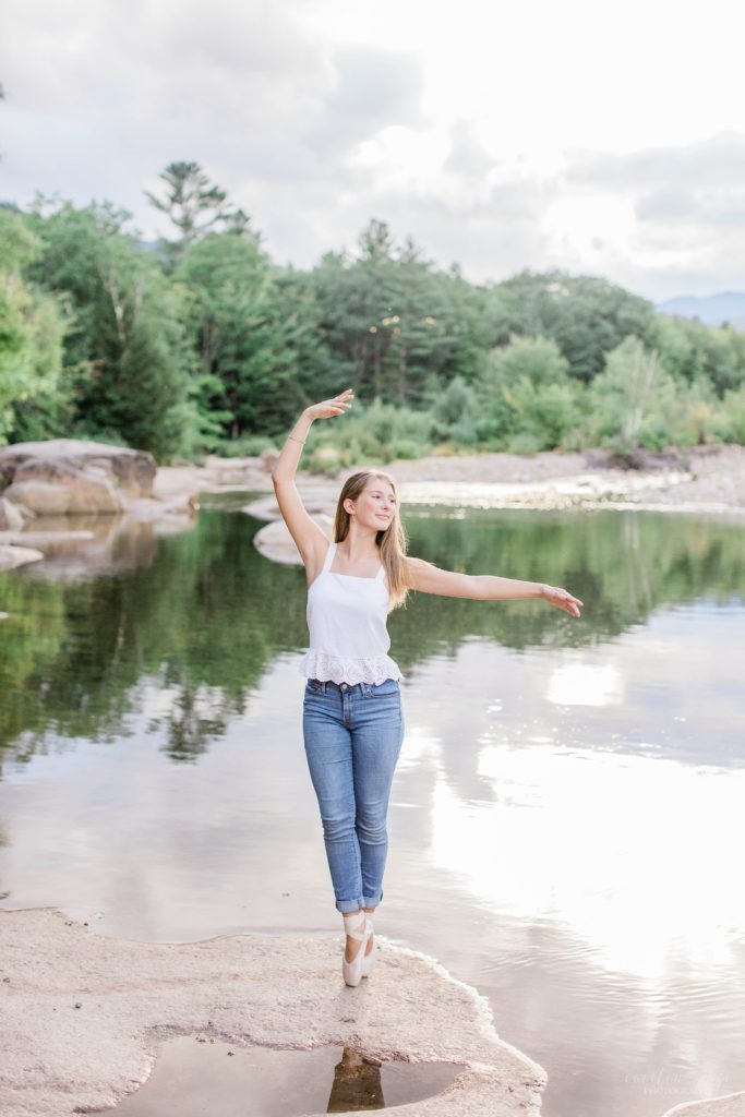Young woman en pointe on a river rock at sunset at the Saco River in New Hampshire