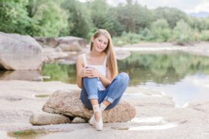 Young woman en pointe on a river rock at sunset at the Saco River in New Hampshire