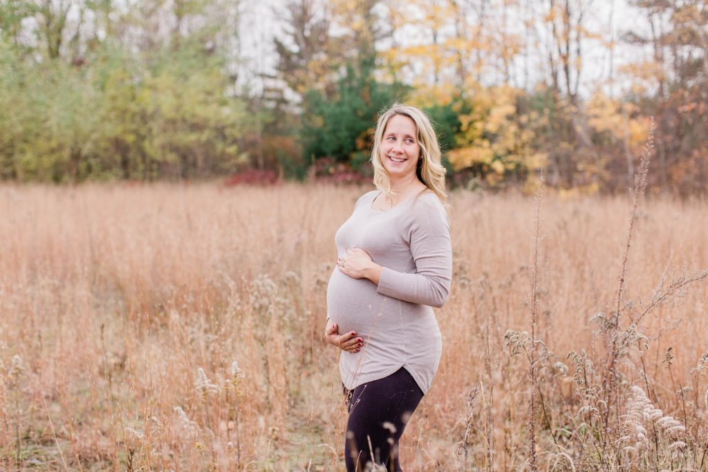Pregnant woman laughing in a field
