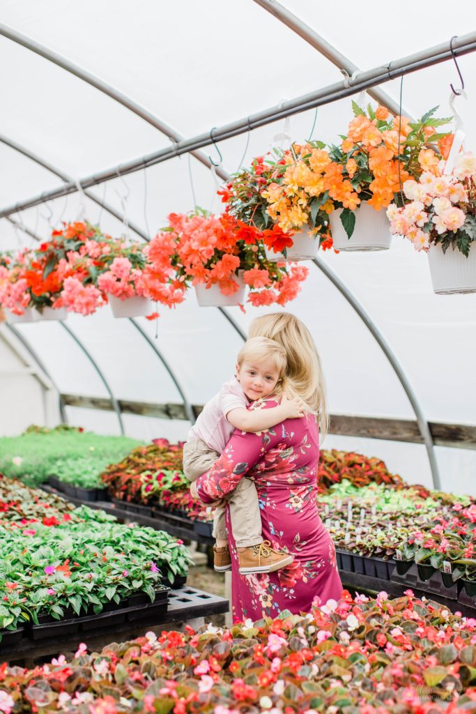 Little boy hugging his mom in a greenhouse